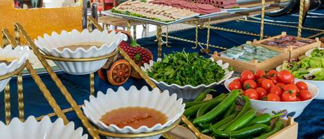 A buffet table with various food items and bowls.
