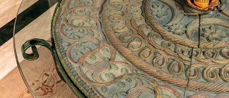 A glass table with intricate floral patterns and a central decorative piece.