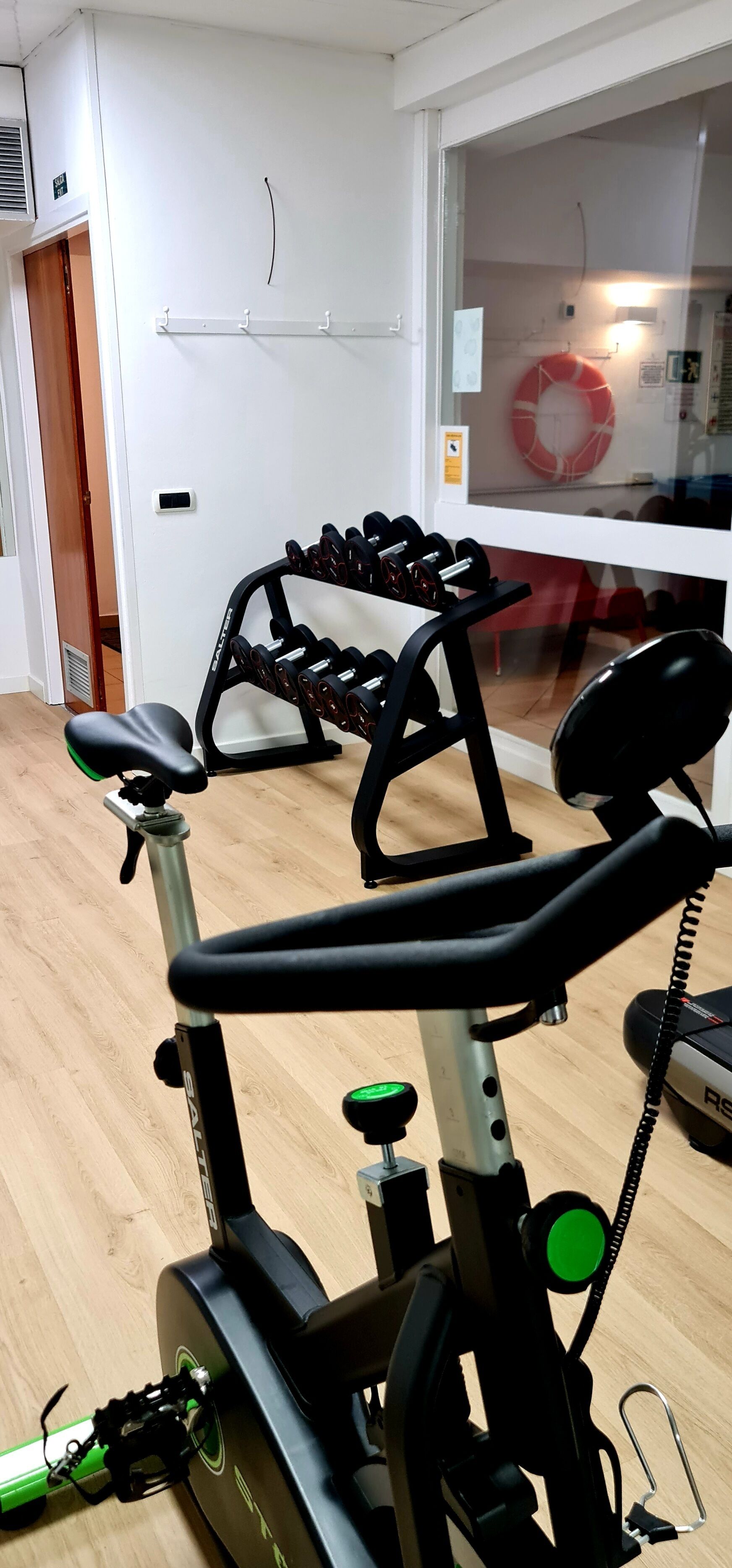 A gym with exercise equipment, including a stationary bike and dumbbells.