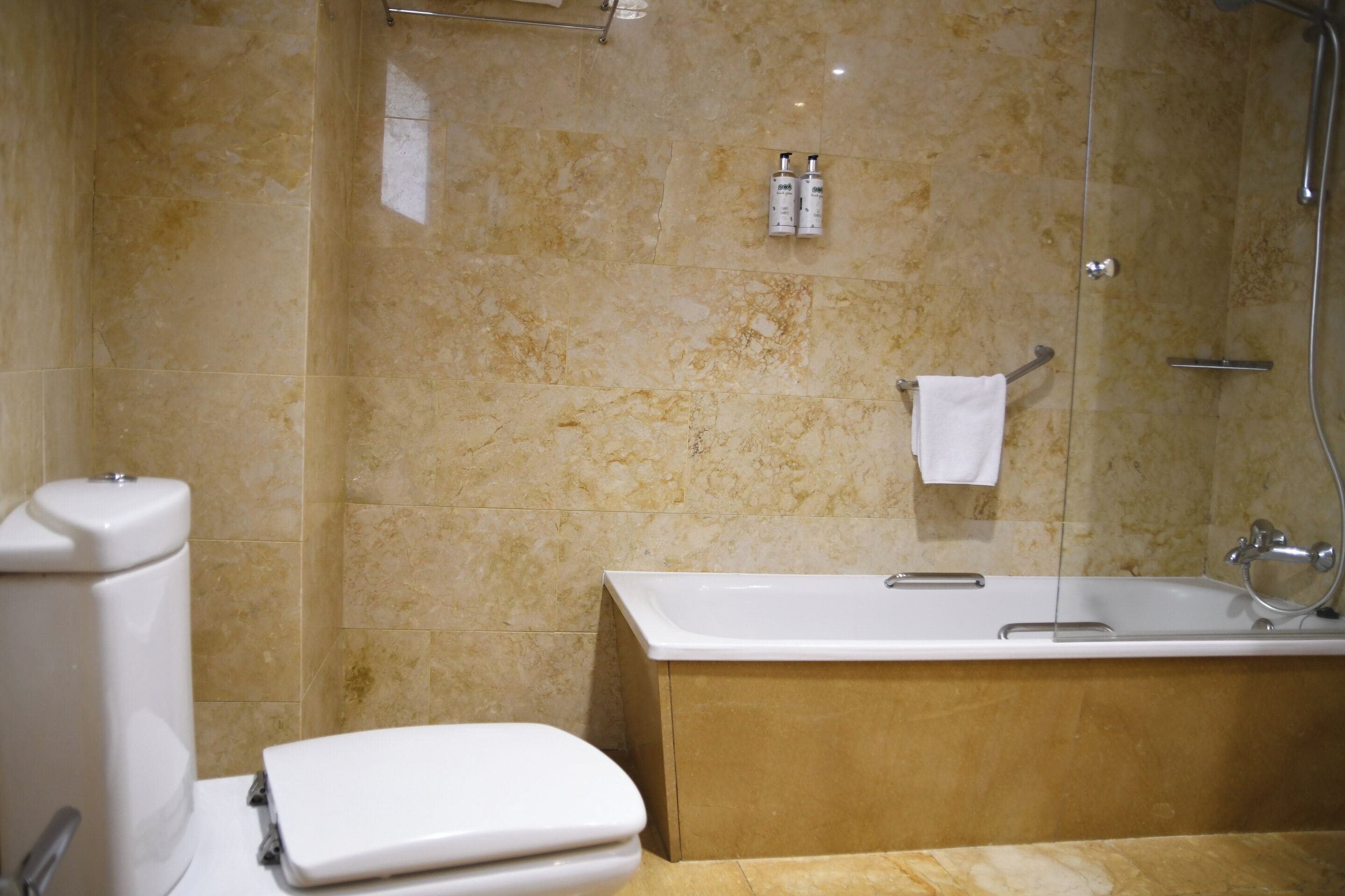 Un baño con inodoro, bañera y ducha.