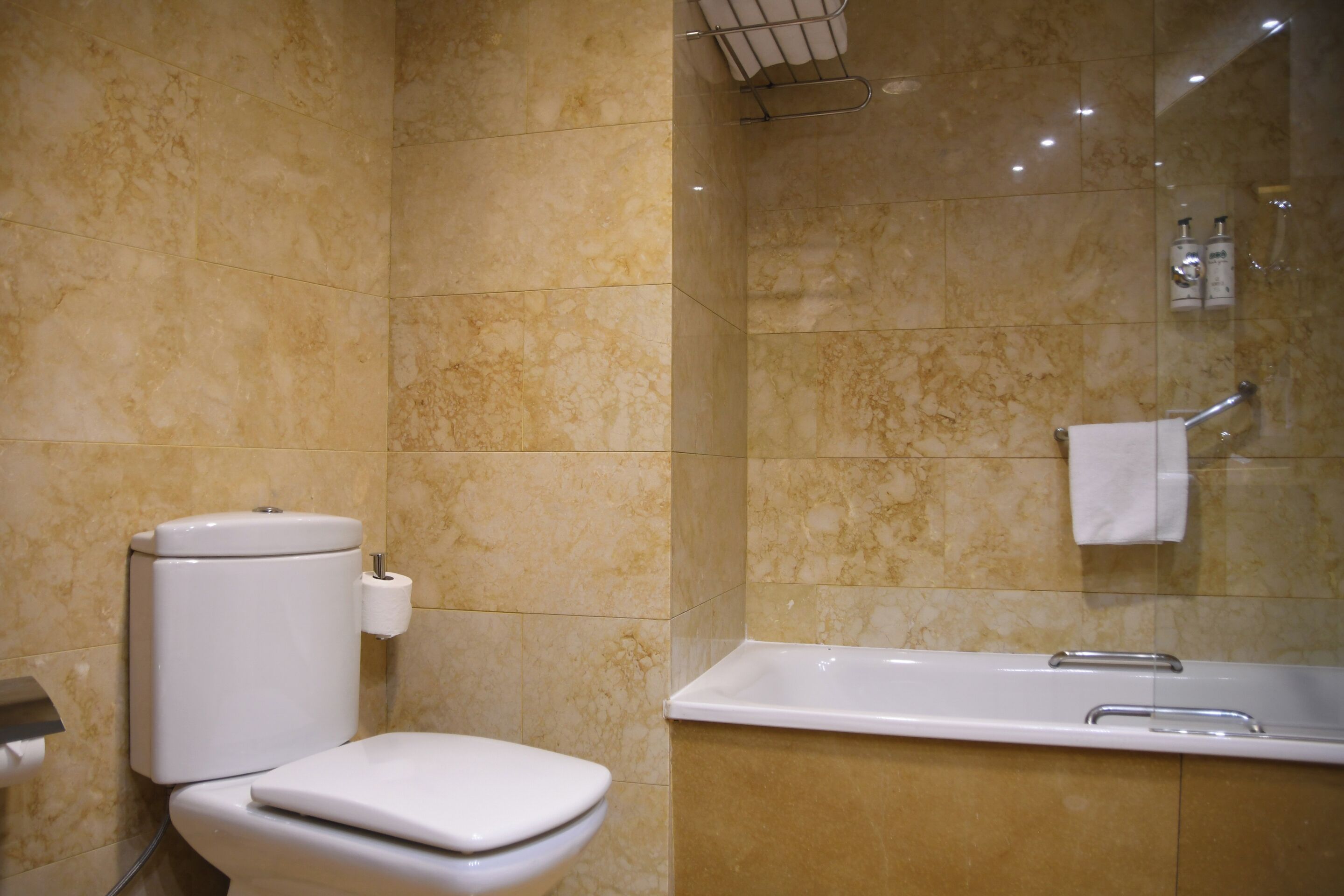 Une salle de bain comprenant des toilettes, une baignoire et une douche à parois de verre.