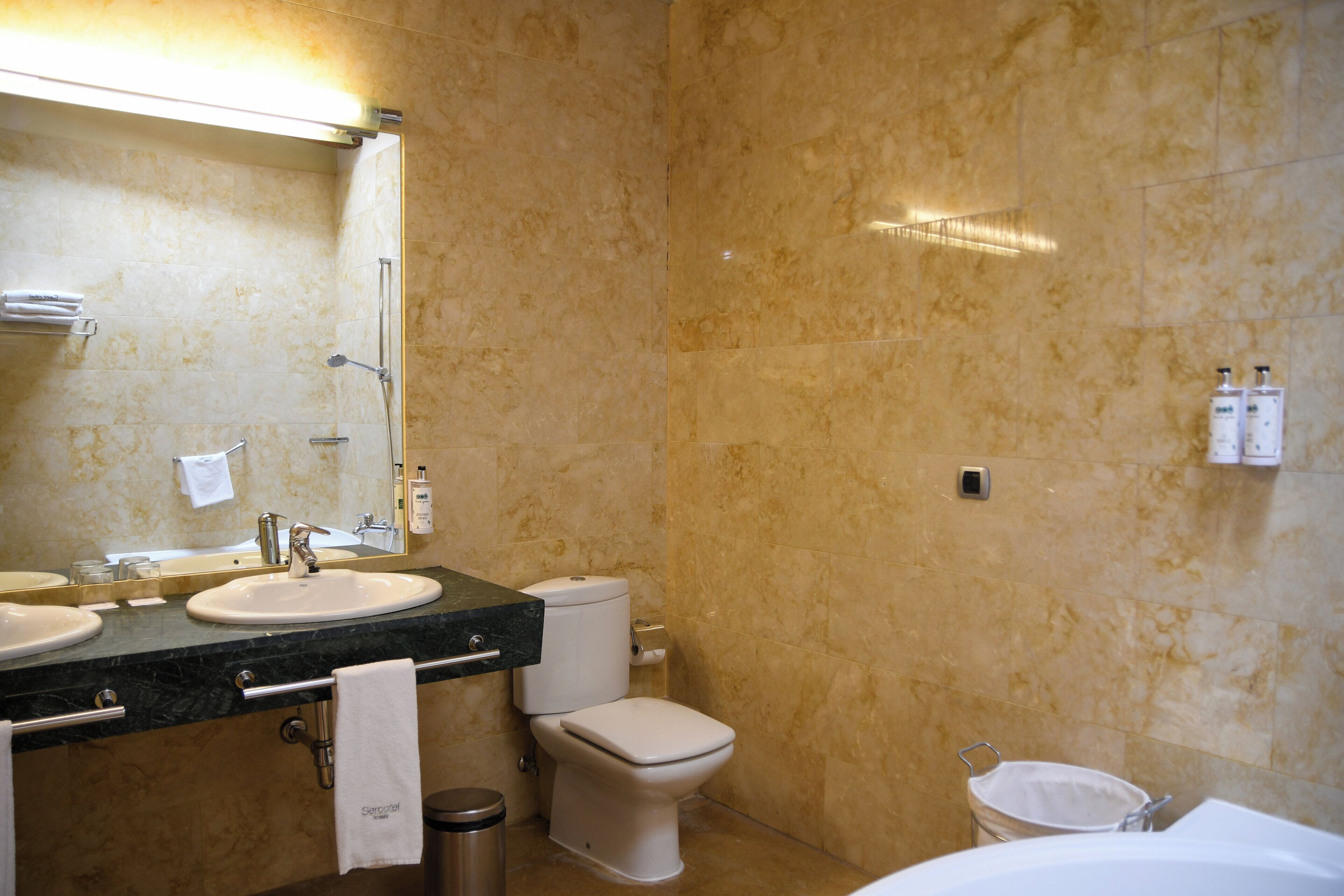 Un baño con dos lavamanos, un inodoro y una bañera.