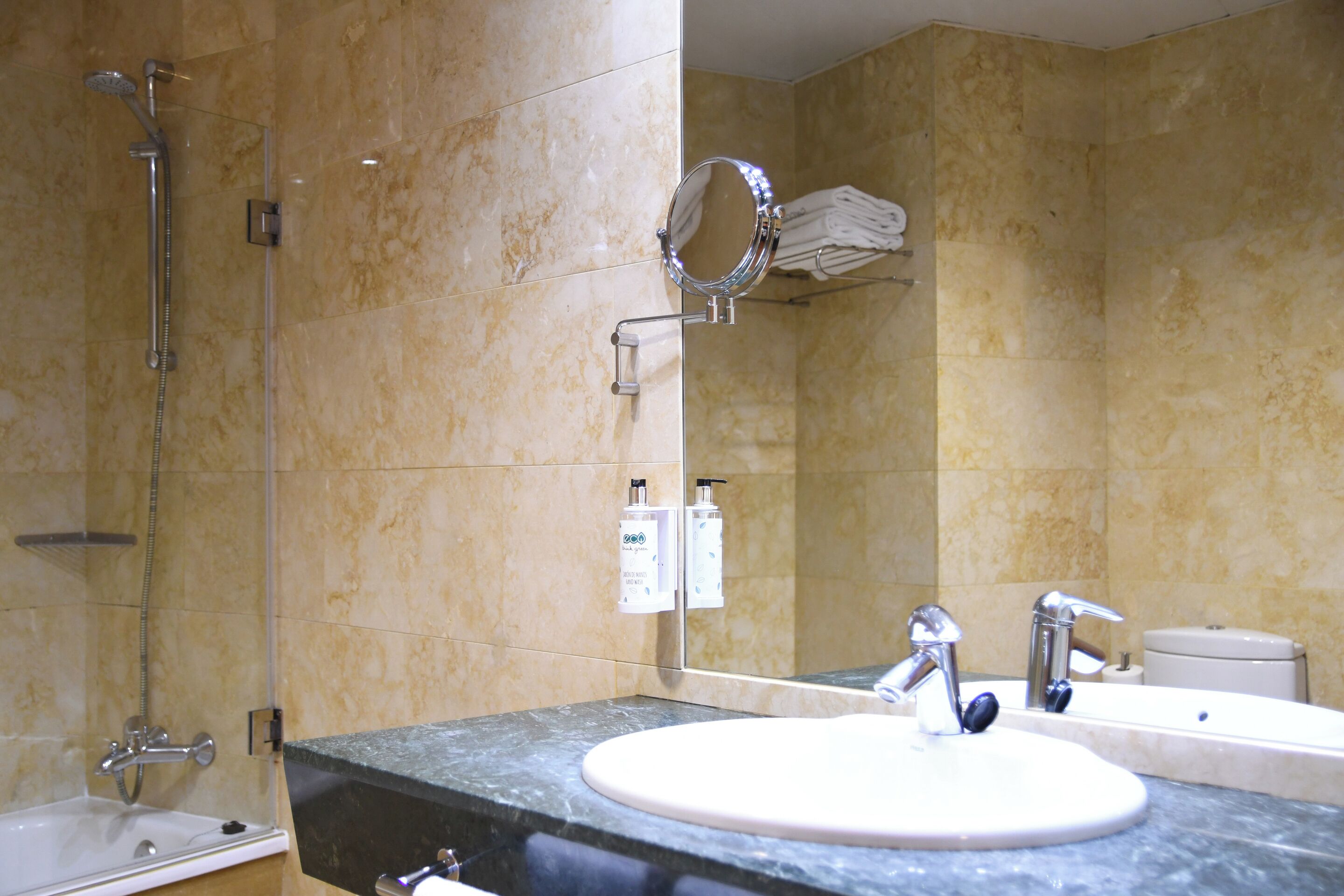 A bathroom with a bathtub, a sink, a mirror, and a towel rack.