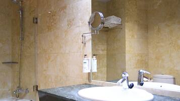 A bathroom with a bathtub, a sink, a mirror, and a towel rack.