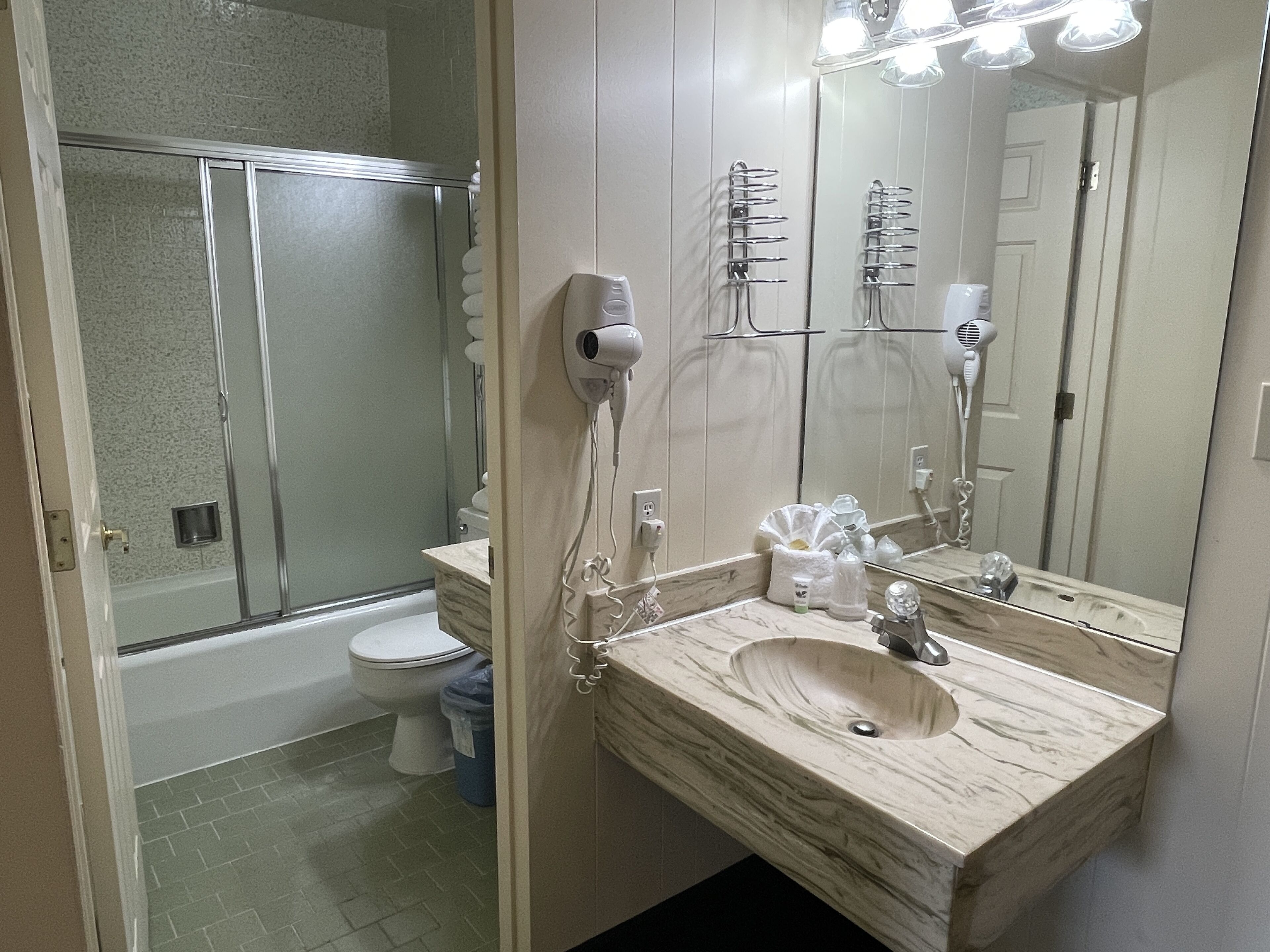 Un bagno con doccia, servizi igienici e lavandino.