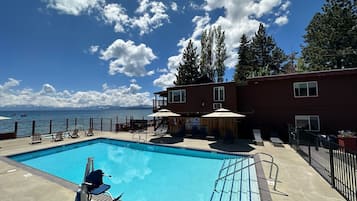 Una piscina al aire libre de temporada, sombrillas