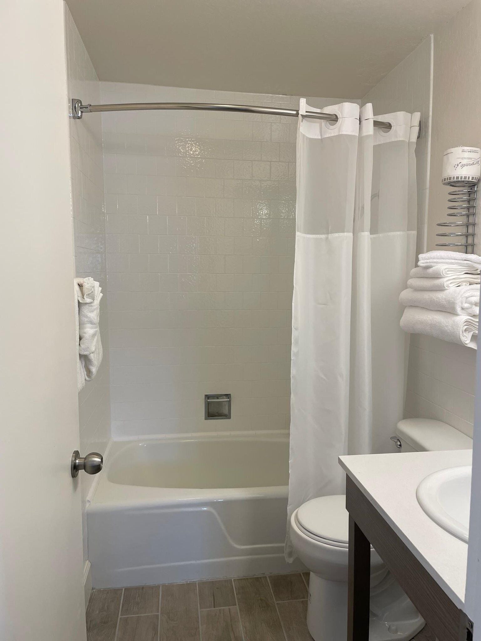 A bathroom with a bathtub, toilet, and a sink.