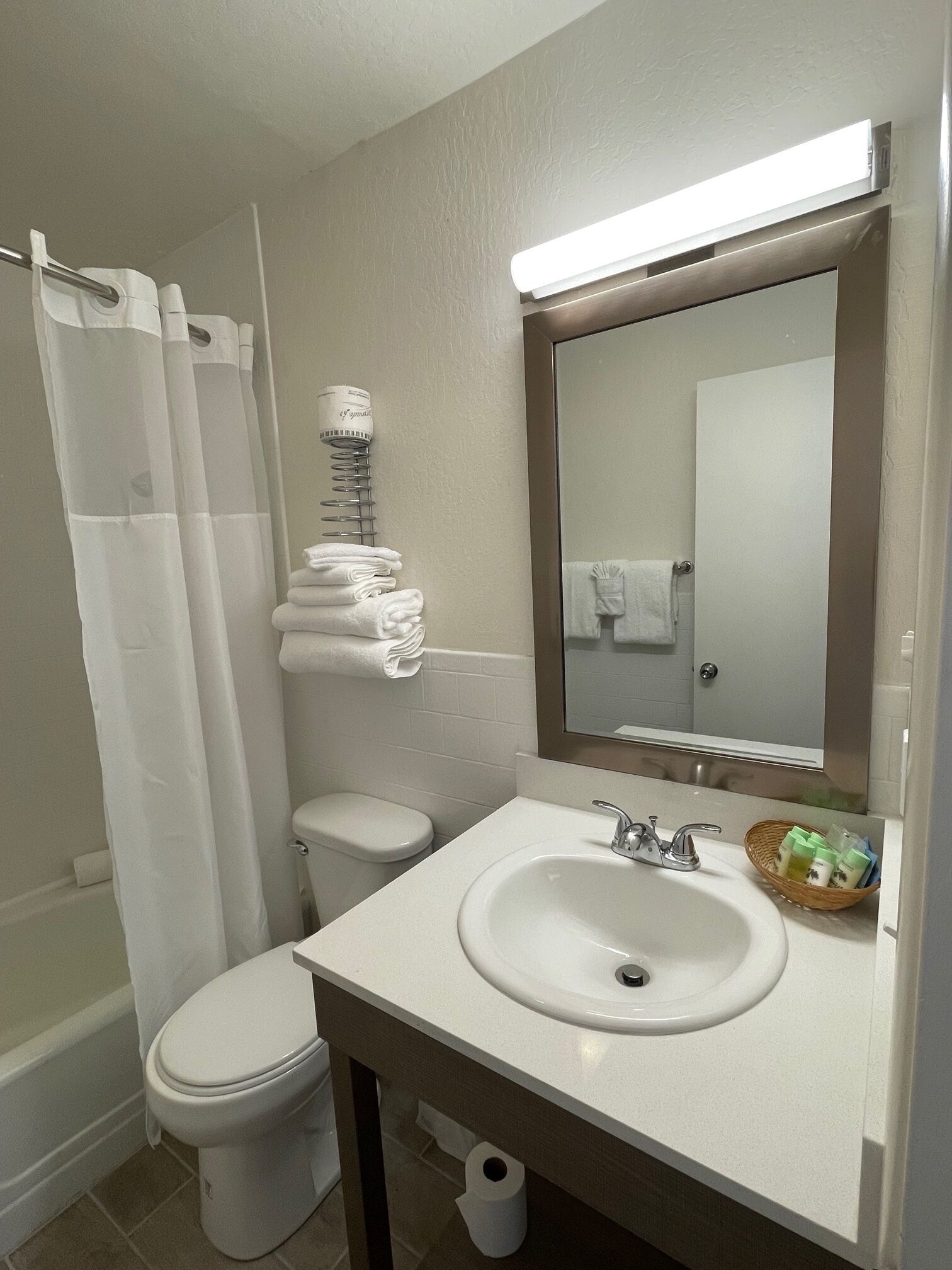 Un baño con inodoro, lavamanos y cortina de ducha.