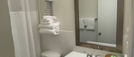 A bathroom with a toilet, sink, and shower curtain.