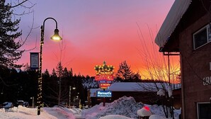 Un sendero cubierto de nieve que conduce a un edificio con un cartel que dice 'Crown Motel' y 'Ferris 40 Lakeview Rooms'.