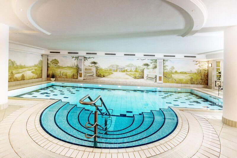 Una piscina cubierta, tumbonas