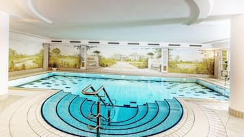 Una piscina cubierta, tumbonas