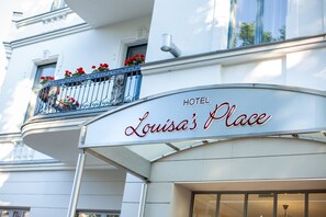 A hotel sign with the name "Louisa's Place" and a balcony with red flowers. - Louisa's Place (Berlin)