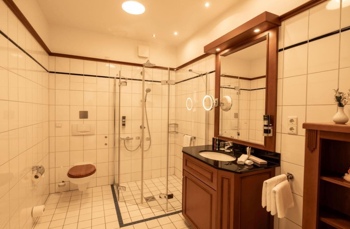 Une salle de bain moderne avec une douche à parois de verre, un meuble-lavabo en bois et un grand miroir.