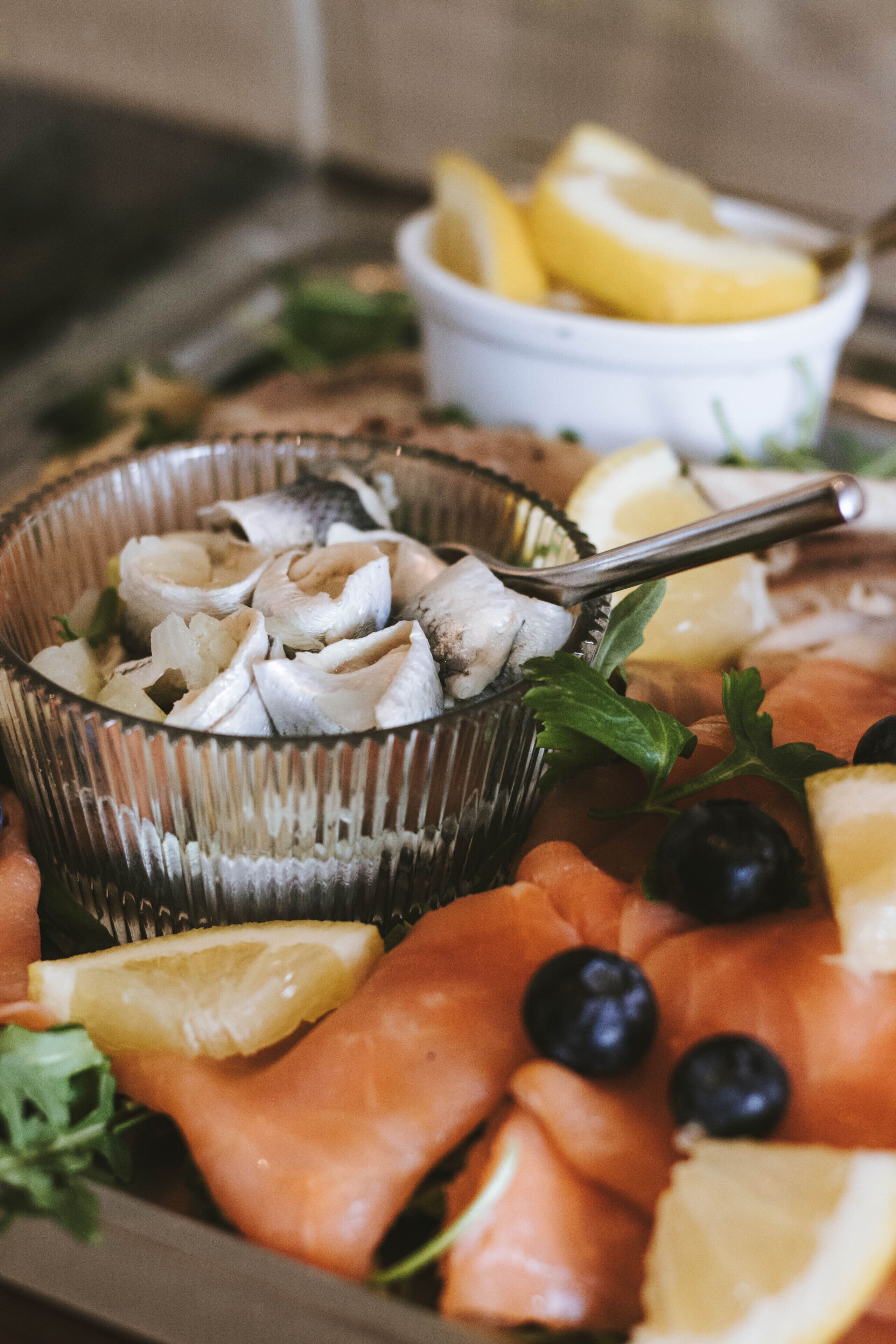 A platter of smoked salmon, fresh blueberries, and lemon slices.
