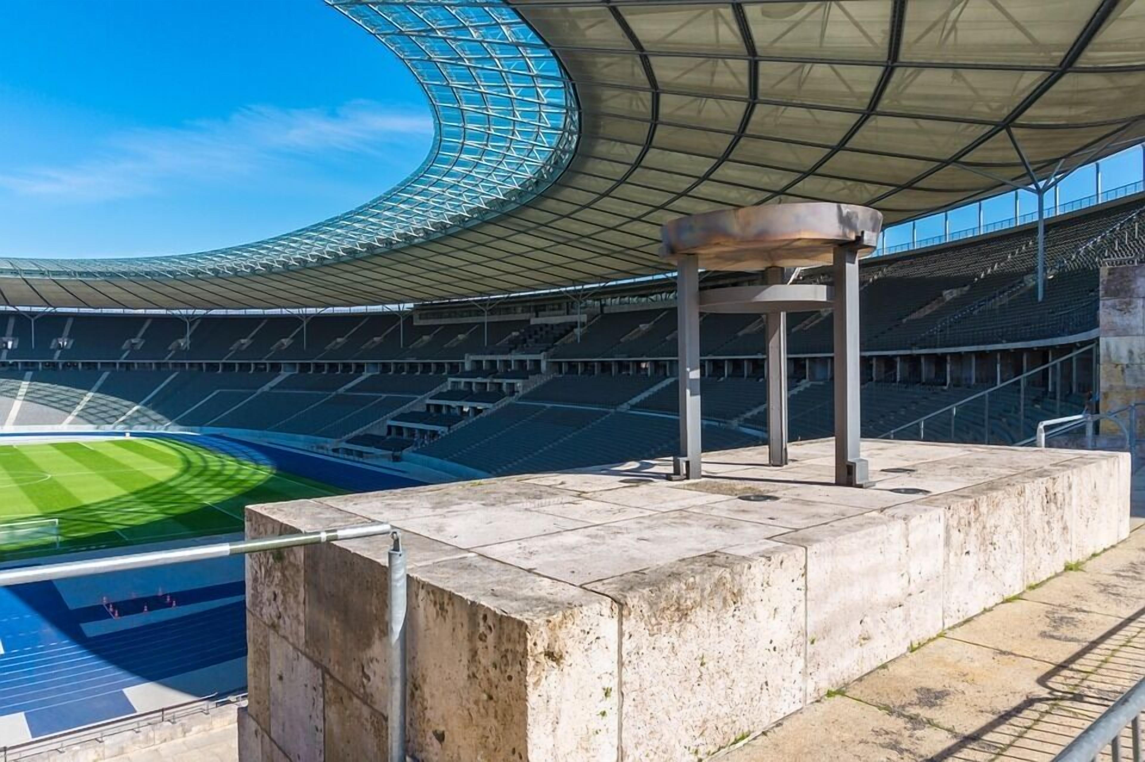 A stadium with a large, curved roof structure and a central open area.