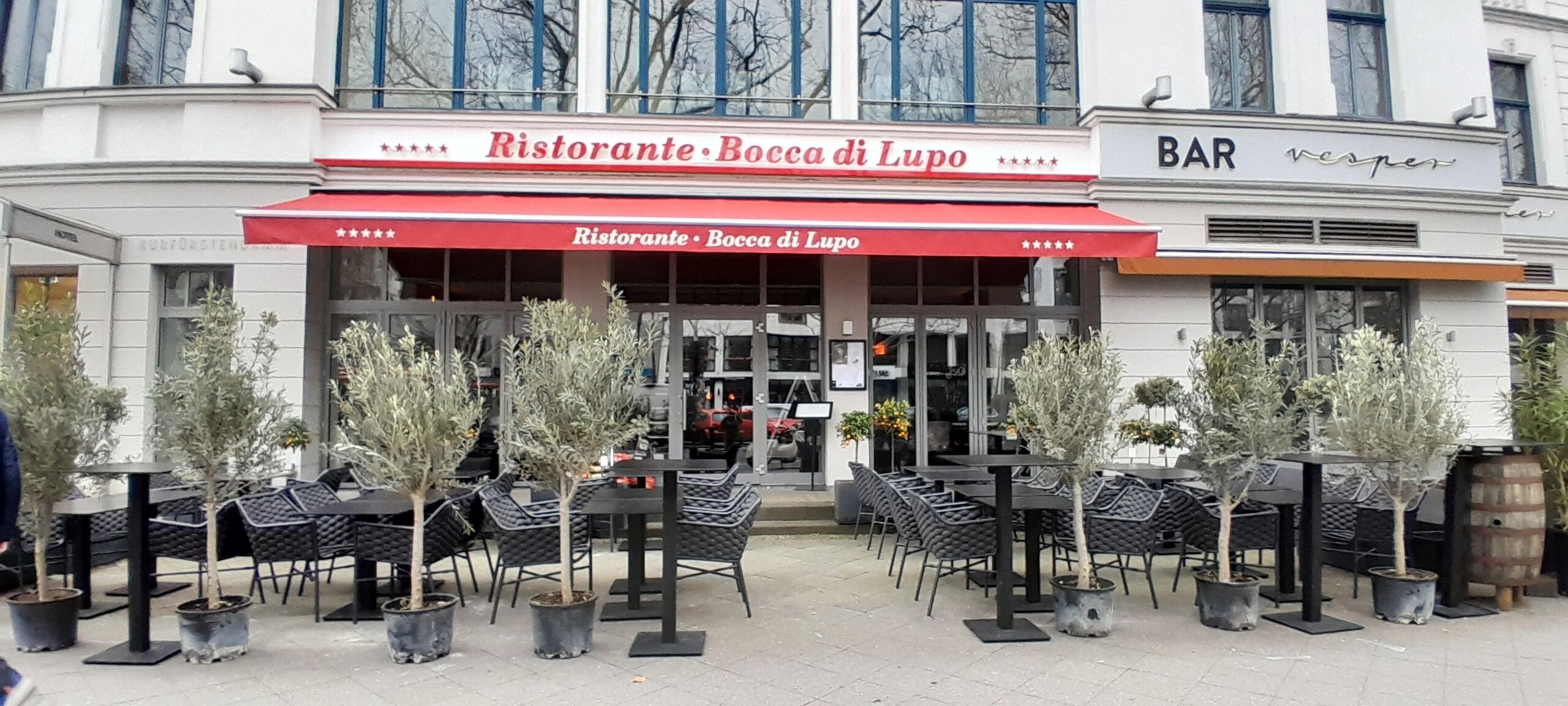 A restaurant named Ristorante Bocca di Lupo with outdoor seating and potted plants.