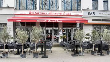 A restaurant named Ristorante Bocca di Lupo with outdoor seating and potted plants.