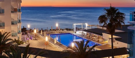 Una piscina al aire libre, sombrillas, tumbonas