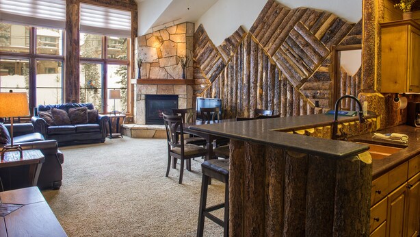 Un salón amplio con chimenea de piedra, un ventanal grande y una zona de estar acogedora.