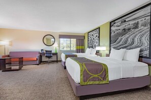 Ein Hotelzimmer mit zwei Betten, einem Schreibtisch, einem Sessel, einer Couch, einem runden Spiegel und einem großen Landschaftsbild an der Wand.