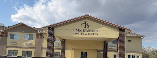 Ein Hotel mit einem gut sichtbaren Schild, auf dem 'Emmetsburg Hotel & Suites' steht, und einem Kennzeichen für barrierefreien Zugang.
