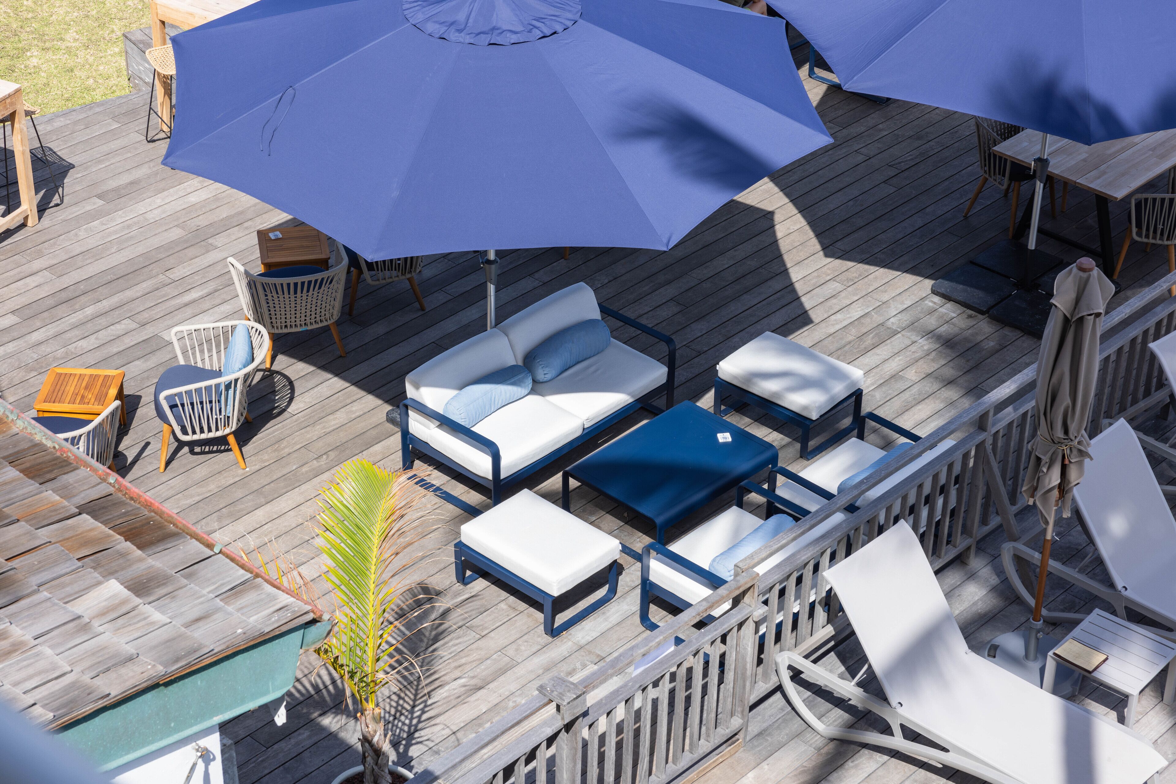 Une terrasse aménagée avec du mobilier d’extérieur, notamment un canapé, des chaises et une table.