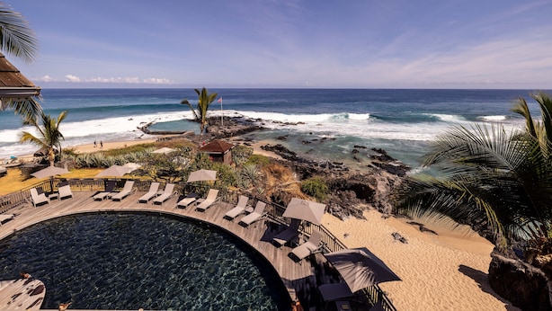 Un resort con piscina, playa y vista al océano.