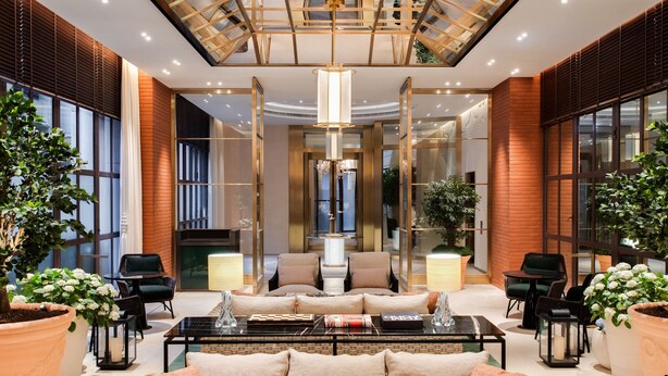 A modern lobby with a central seating area, large windows, and a skylight. - Lanson Place Causeway Bay, Hong Kong (Hong Kong)