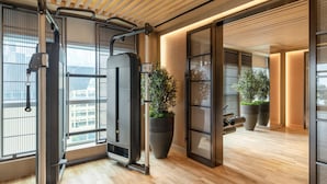 A modern gym with exercise equipment, large windows, and potted plants. - Lanson Place Causeway Bay, Hong Kong (Hong Kong)