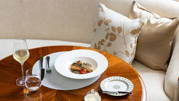 Uma mesa de jantar com um prato de comida, uma taça de vinho e talheres.