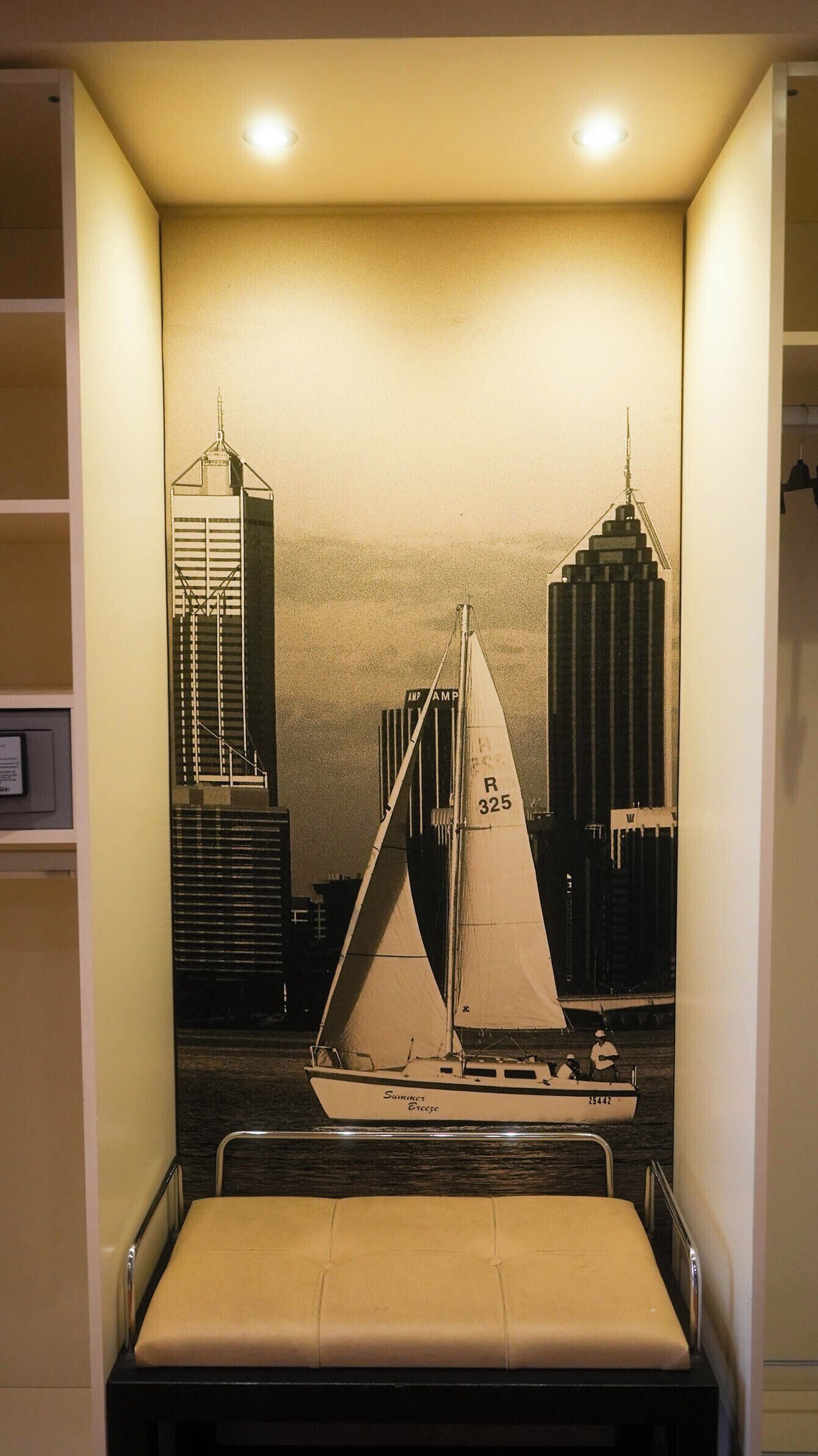 Una habitación con una cama, un mural de un velero y dos edificios altos.