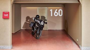 A motorcycle parked inside a building with a number 160 sign on the wall.
