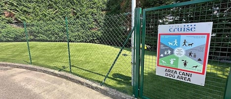 Zona delimitada para perros con un cartel que indica las normas.