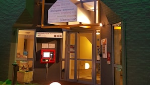 A hotel entrance with a sign reading "BRIT HOTEL" and a welcome sign in multiple languages. - Brit Hotel Tours Nord (Tours)
