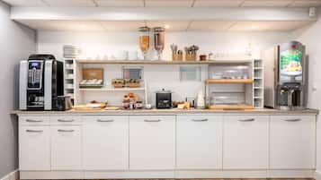 A modern kitchen with a coffee machine, toaster, and refrigerator.