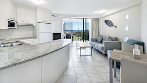 A modern kitchen with white cabinets, a granite countertop, and a built-in oven.