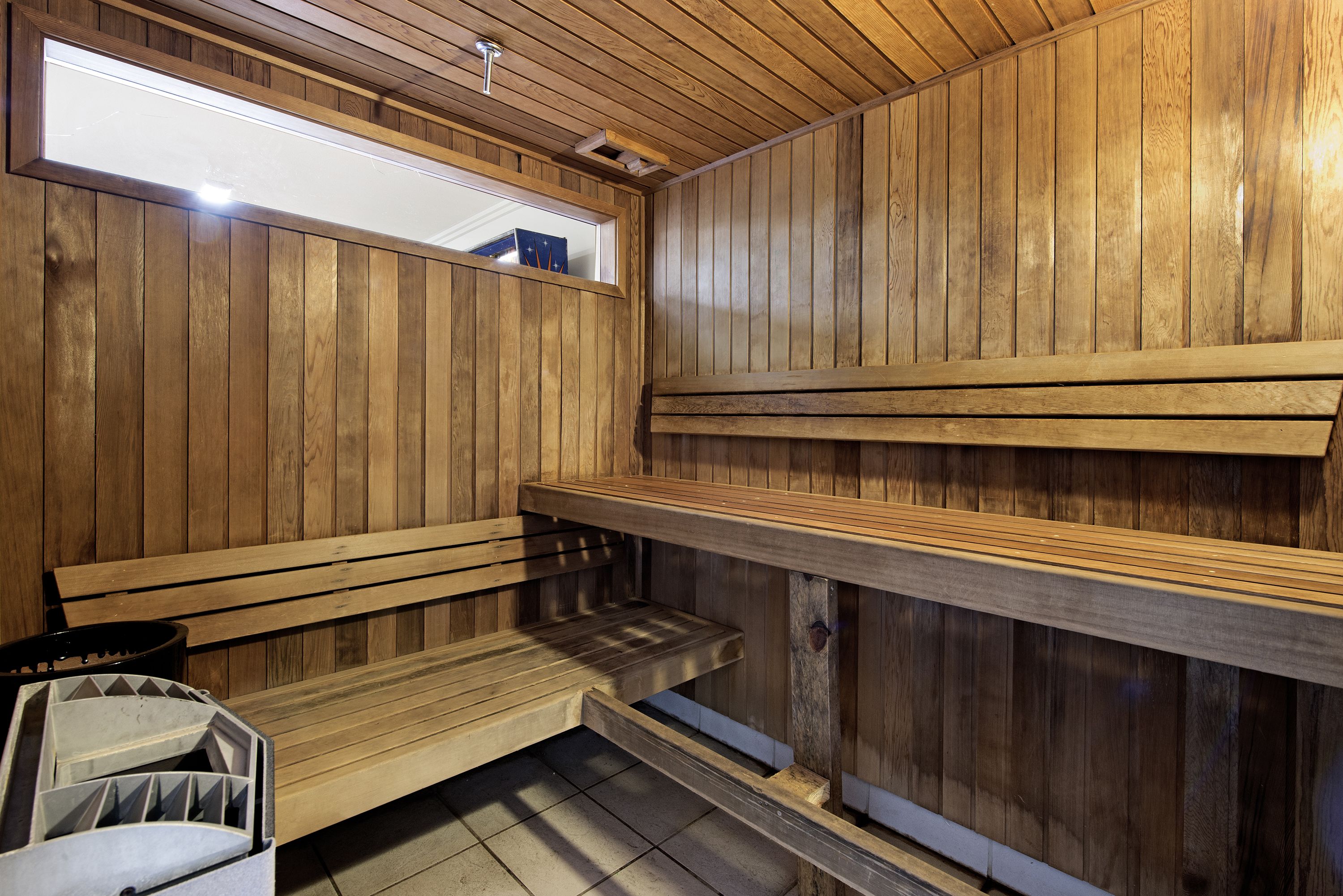 Un sauna avec des bancs en bois et une fenêtre.