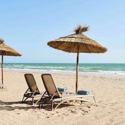 Playa privada, playa de arena blanca, camastros y sombrillas