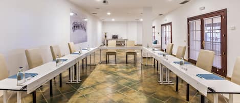 A conference room with a long table, chairs, and a projector.