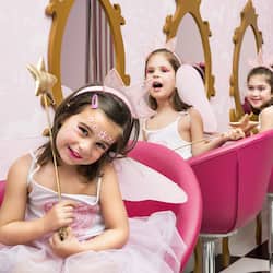 Experience a classic salon setting with pink salon chairs, mirrors, and a checkered floor.