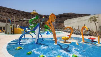 A water park with slides, a pool, and lounge chairs.