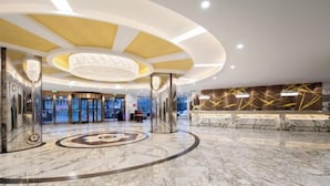 A spacious lobby with a marble floor, a central circular design, and a reception desk with a modern design. - Chengdu Pearl International Hotel (Chengdu)