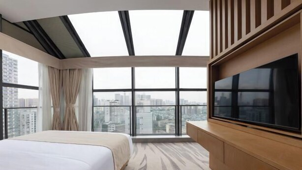 A modern hotel room with a large bed, a TV, and a city view through large windows. - Chengdu Pearl International Hotel (Chengdu)
