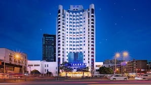 A high-rise hotel with a modern design, featuring a prominent entrance with illuminated signage. - Chengdu Pearl International Hotel (Chengdu)