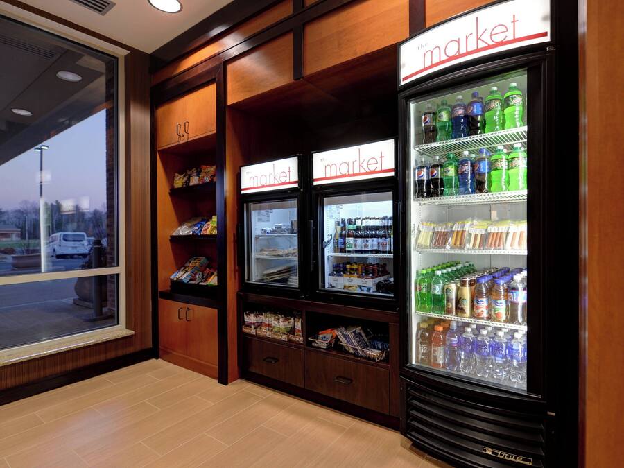 A store interior with refrigerated display cases labeled "market" and shelves stocked with various products.