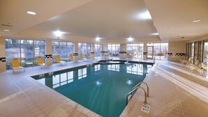 A large indoor swimming pool with clear water, surrounded by yellow chairs and a tiled floor. - Fairfield Inn & Suites by Marriott Wausau (Schofield)