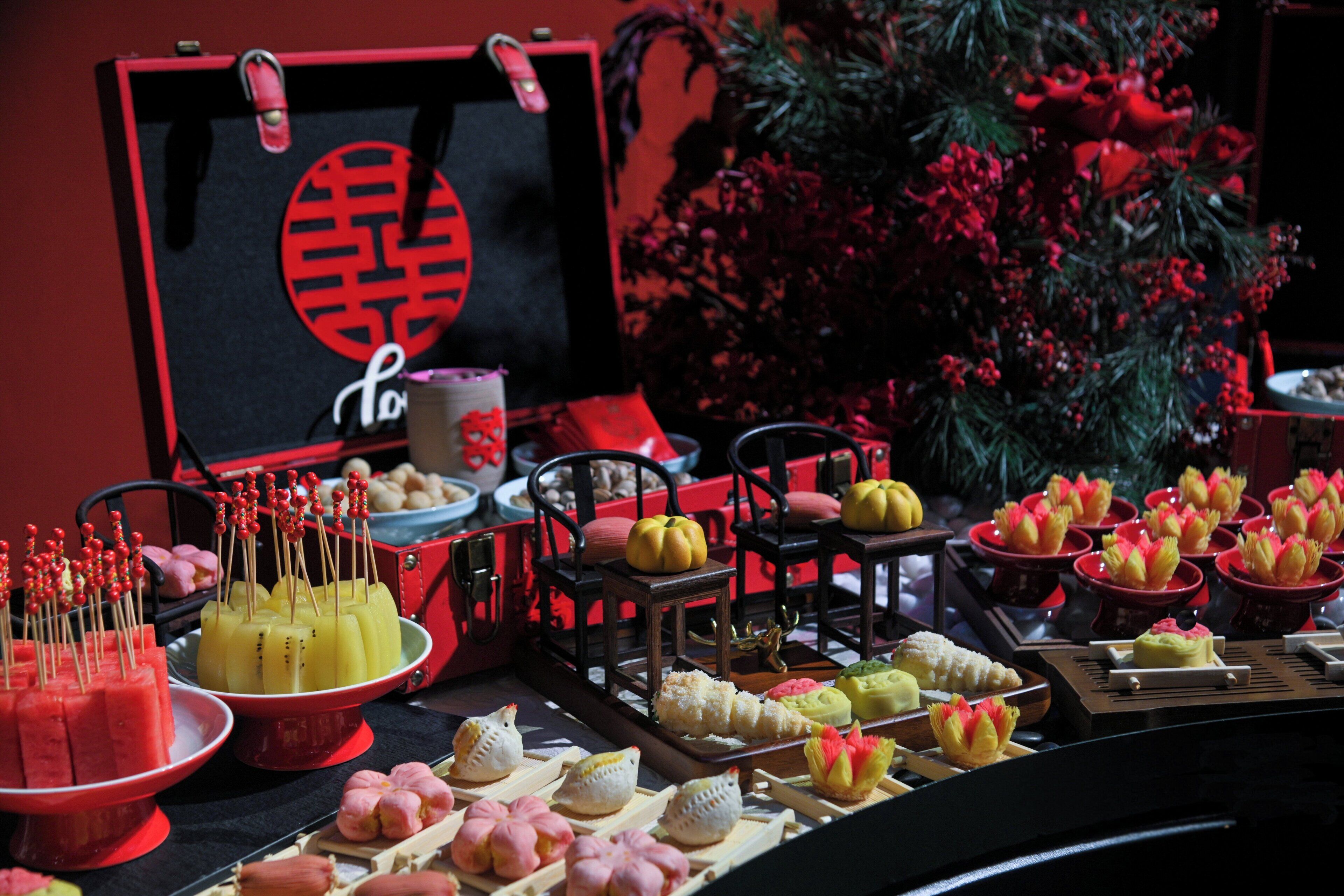 A buffet table with various food items and a decorative backdrop.