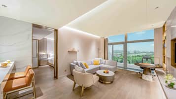 A spacious living room with a large window, a sofa, a coffee table, and a dining area.