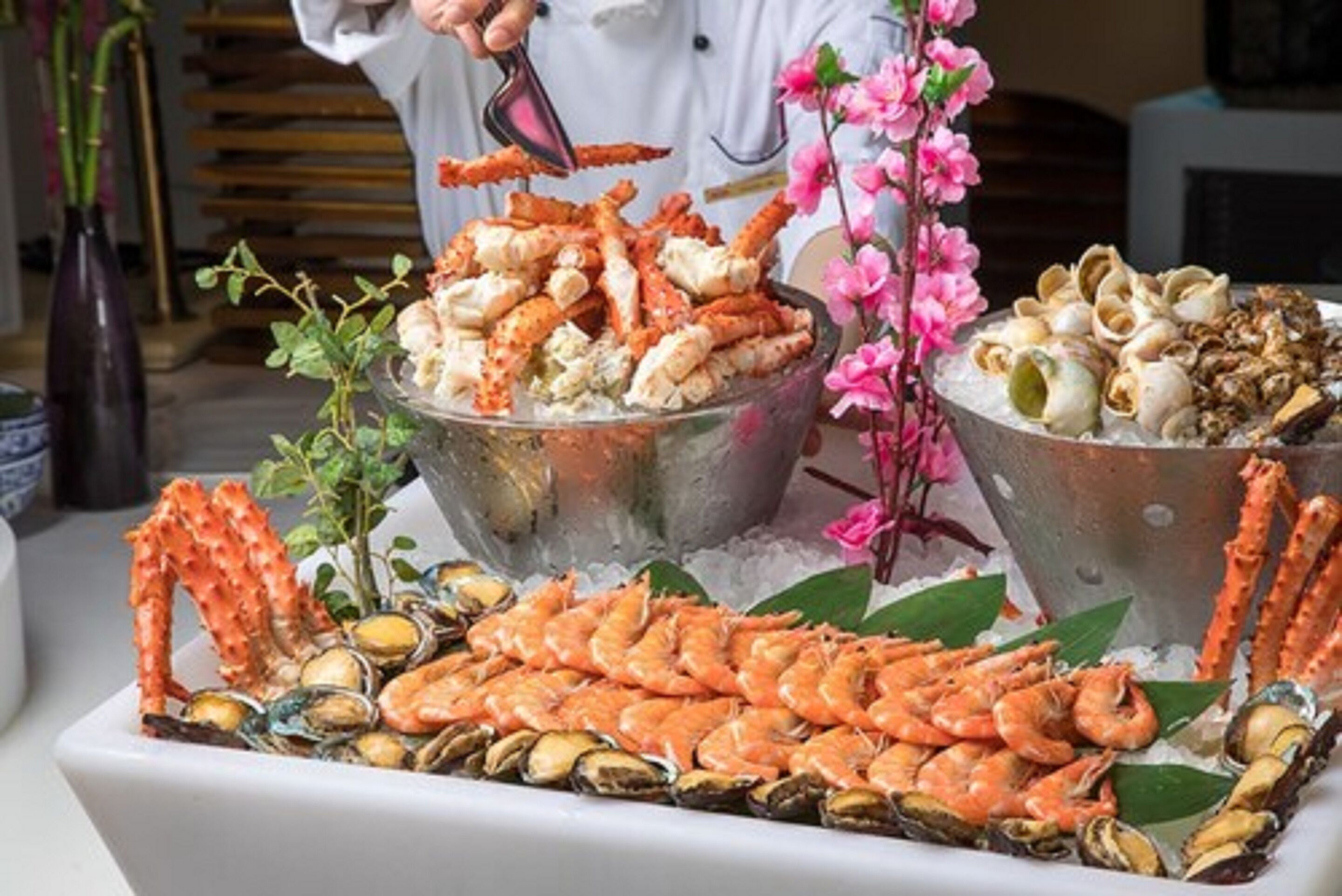 A seafood platter with various shellfish and crab legs, arranged on a bed of ice.
